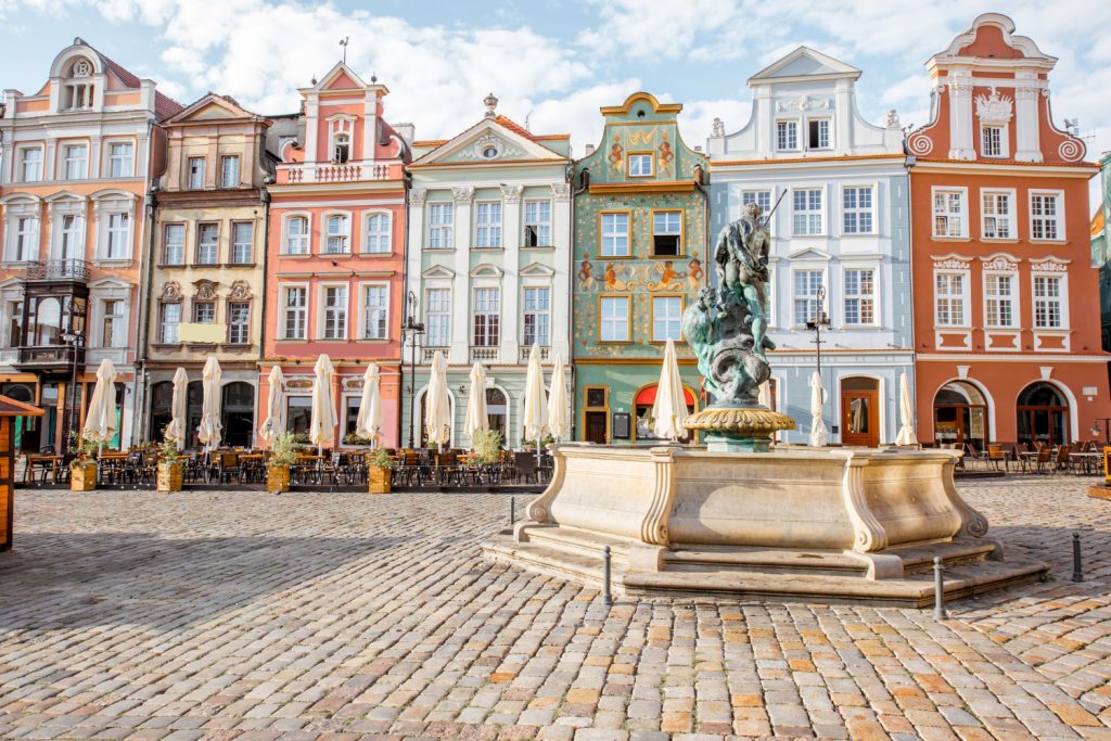 Widok na piękne stare budynki z fontanną Neptuna na rynku w Poznaniu podczas porannego światła w Polsce